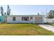 Charming single-story white home with a one-car garage and a green front lawn at 596 S Bayshore Dr, Madeira Beach, FL 33708