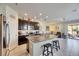 A view of the kitchen with dark cabinets, granite countertops, tile floors and access to the living room at 6907 Holly Heath Dr, Riverview, FL 33578