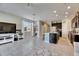 Bright open-concept living room with tile floors, large windows and dark kitchen cabinets at 6907 Holly Heath Dr, Riverview, FL 33578