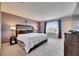 This main bedroom features soft carpet, a large window, and elegant decor at 6907 Holly Heath Dr, Riverview, FL 33578