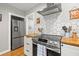 Modern kitchen featuring stainless steel appliances, white cabinets, and butcher block countertops at 777 29Th N Ave, St Petersburg, FL 33704