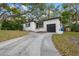 Charming one-story home with a black roof and a long driveway surrounded by beautiful trees at 803 S Evergreen Ave, Clearwater, FL 33756