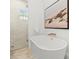 Bright bathroom features a soaking tub with gold hardware, tile floors, and walk in shower at 803 S Packwood Ave, Tampa, FL 33606