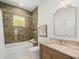 Bathroom features a white tub, tiled shower and vanity with granite countertop at 803 S Packwood Ave, Tampa, FL 33606
