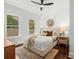 Bright bedroom with multiple windows, plush bed, ceiling fan, and decorative lamps at 803 S Packwood Ave, Tampa, FL 33606
