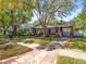 Attractive neighborhood home with a large tree, cozy front porch and driveway to a carport at 803 S Packwood Ave, Tampa, FL 33606