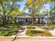 Inviting craftsman-style house with a brick-columned porch, mature trees, and lush green landscaping at 803 S Packwood Ave, Tampa, FL 33606