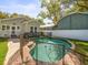 Backyard swimming pool with safety fence surrounded by lush landscaping and mature trees at 803 S Packwood Ave, Tampa, FL 33606