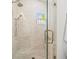 Shower features white tile surround, glass door and herringbone tile flooring at 803 S Packwood Ave, Tampa, FL 33606