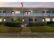 Condo complex exterior showing manicured hedges, white walls, red door trim, and an American flag at 8220 112Th N St # 206, Seminole, FL 33772