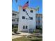Condominium building exterior with an American flag, lush landscaping and impact windows at 8402 111Th St # 303, Seminole, FL 33772
