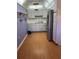 Kitchen showcasing white cabinets, laminate flooring, stainless steel appliances, and modern lighting at 8402 111Th St # 303, Seminole, FL 33772
