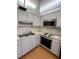 Charming kitchen featuring stainless steel appliances, laminate flooring, and ample cabinet space at 8402 111Th St # 303, Seminole, FL 33772