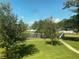 Window view of community space with mature trees, lake and outdoor seating area at 8402 111Th St # 303, Seminole, FL 33772