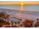 Beautiful beach view with an adjacent pool and lounge area during sunrise at 880 Mandalay Ave # N802, Clearwater Beach, FL 33767