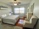Inviting bedroom with wood floors, a patterned chair, and soft, natural light at 880 Mandalay Ave # N802, Clearwater Beach, FL 33767