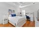 Bright bedroom with white walls, hardwood floors, ceiling fan, and a full work desk, chair, and shelving unit at 926 Anchorage Rd, Tampa, FL 33602