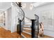 Elegant curved staircase with wood treads, wrought iron railings, and decorative lighting at 926 Anchorage Rd, Tampa, FL 33602