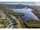 Scenic aerial view of waterfront homes nestled amongst the lush landscape and blue waterway at 1020 Lake Avoca Dr, Tarpon Springs, FL 34689