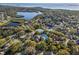 Scenic aerial shot of a community with a lake, swimming pool, and tennis courts near the ocean at 1020 Lake Avoca Dr, Tarpon Springs, FL 34689