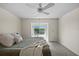 Comfortable bedroom with carpet, ceiling fan, and view of a tree-lined lake at 1020 Lake Avoca Dr, Tarpon Springs, FL 34689