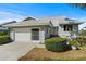 Charming single-story home with a well-manicured lawn, attached garage, and decorative front garden at 1020 Lake Avoca Dr, Tarpon Springs, FL 34689
