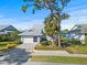 Charming single Gathering home with an attached garage, manicured lawn, and mature trees at 1020 Lake Avoca Dr, Tarpon Springs, FL 34689