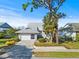 Inviting single-story home featuring a well-maintained lawn and an attached two car garage at 1020 Lake Avoca Dr, Tarpon Springs, FL 34689
