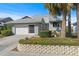 Charming single-story home with a well-manicured lawn, attached garage, and decorative front garden at 1020 Lake Avoca Dr, Tarpon Springs, FL 34689