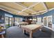 Game room with two pool tables, coffered ceiling, wet bar, and ample seating at 1020 Lake Avoca Dr, Tarpon Springs, FL 34689