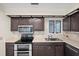 A kitchen with stainless steel appliances, dark cabinetry, and a bright window for natural light at 1020 Lake Avoca Dr, Tarpon Springs, FL 34689