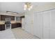 Full kitchen view with stainless appliances, dark cabinetry, tile flooring, and white pantry doors at 1020 Lake Avoca Dr, Tarpon Springs, FL 34689