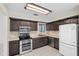 Traditional kitchen featuring dark brown cabinetry, stainless steel appliances, and neutral countertops at 1020 Lake Avoca Dr, Tarpon Springs, FL 34689