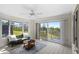 Bright sunroom featuring a ceiling fan, comfortable seating, and views of a private yard at 1020 Lake Avoca Dr, Tarpon Springs, FL 34689