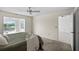 Bright main bedroom featuring a ceiling fan and sliding glass doors to the lanai at 1020 Lake Avoca Dr, Tarpon Springs, FL 34689