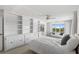 Large bedroom featuring built-in shelves, carpet, and a sitting area by the window at 1020 Lake Avoca Dr, Tarpon Springs, FL 34689