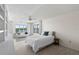 Light filled main bedroom with serene lake views, carpet, and small seating area at 1020 Lake Avoca Dr, Tarpon Springs, FL 34689
