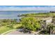 Aerial view of waterfront home, lush greenery, and access to open water bay at 104 Westbrook Ct, Safety Harbor, FL 34695