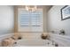 Bathroom features a soaking tub with a chandelier and privacy shutters at 104 Westbrook Ct, Safety Harbor, FL 34695