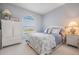 Well-lit bedroom features a cozy bed with coastal-themed bedding and a white armoire at 104 Westbrook Ct, Safety Harbor, FL 34695