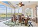 Dining room with high ceilings, a ceiling fan, water views and floor to ceiling windows at 104 Westbrook Ct, Safety Harbor, FL 34695