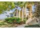 Beautiful two-story tan home with lush landscaping and a view of the water at 104 Westbrook Ct, Safety Harbor, FL 34695