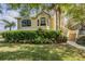 Charming tan home with well-maintained landscaping and a sidewalk to the front steps at 104 Westbrook Ct, Safety Harbor, FL 34695