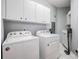 Clean laundry room featuring a Whirlpool washer and dryer with white cabinetry at 104 Westbrook Ct, Safety Harbor, FL 34695