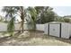 A fenced backyard with a small storage shed and a palm tree, providing space for outdoor activities and storage at 10440 Laval St, Spring Hill, FL 34608