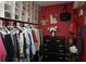 Organized walk-in closet featuring hanging clothes, storage boxes, and a stylish dresser at 10440 Laval St, Spring Hill, FL 34608