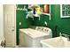 A dedicated laundry room with modern washer and dryer units, utility sink and shelving at 10440 Laval St, Spring Hill, FL 34608