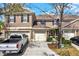 Exterior of a townhome with a two-car garage, dark shutters, and a landscaped yard at 11190 Windsor Place Cir, Tampa, FL 33626