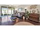 Well-lit living room featuring hardwood floors, leather sofa, tasteful décor, and sliding glass doors at 11190 Windsor Place Cir, Tampa, FL 33626