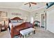 Comfortable main bedroom offering a ceiling fan and a cozy bench in front of the bed at 11190 Windsor Place Cir, Tampa, FL 33626